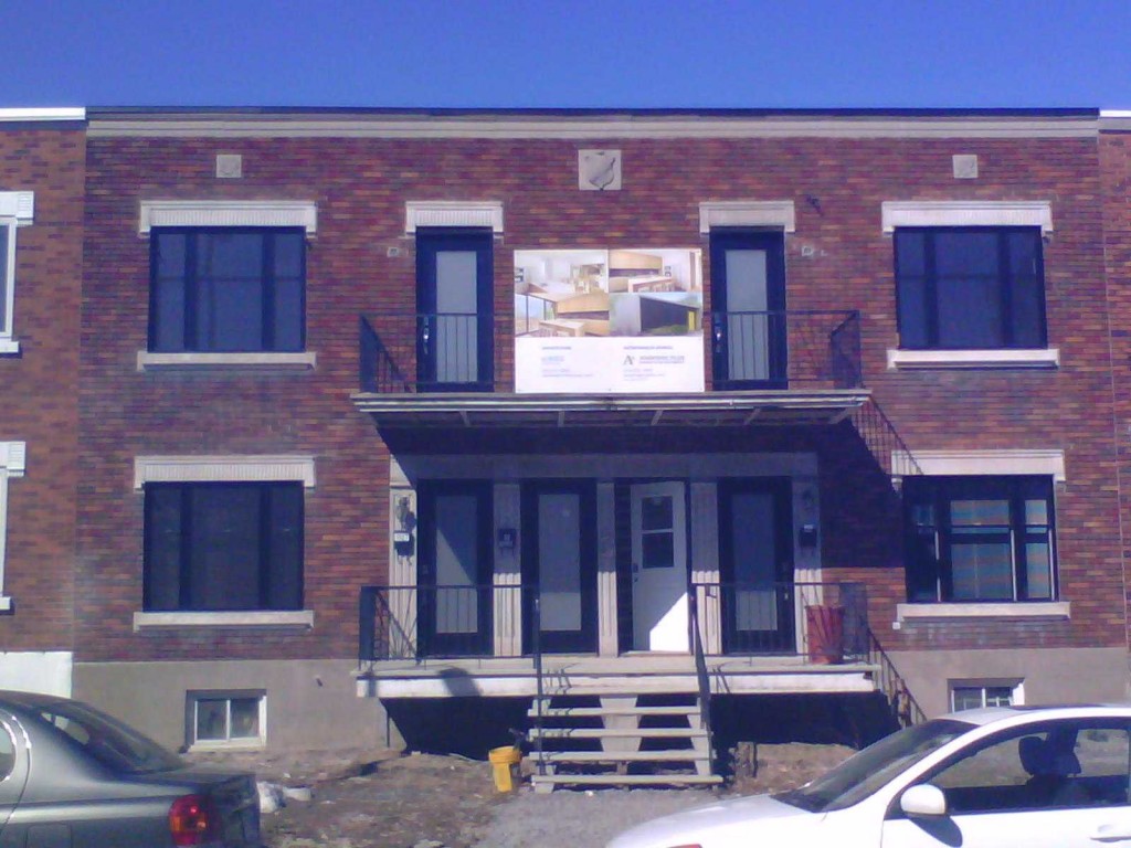 Façade de brique aux chambranles de pierre restaurée à Montréal